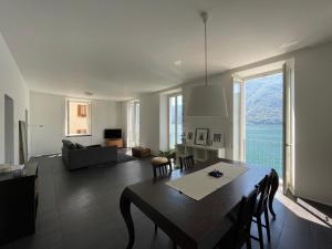 een woonkamer met een eettafel en een bank bij Lugano Lake, nido del cigno in Oria