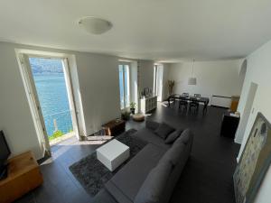 een woonkamer met een bank en een tafel bij Lugano Lake, nido del cigno in Oria