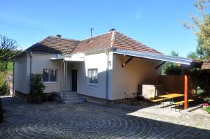 Guesthouse Djurić في نيجوتين: منزل أبيض صغير مع سقف مزفلت