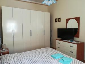 1 dormitorio con 1 cama y TV de pantalla plana en Casa Silipi, en Gallico