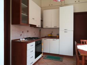 a kitchen with white cabinets and a stove top oven at Casa Silipi in Gallico