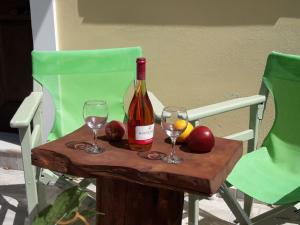 a bottle of wine and two glasses on a table at Dourios Ippos Apartments in Frikes
