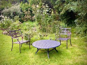 2 Stühle und ein Tisch im Gras in der Unterkunft Spacious King Room with Ensuite in Launton