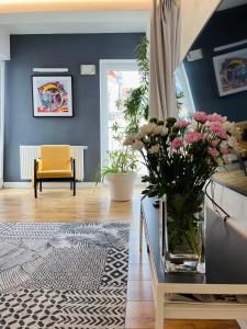 a living room with a vase of flowers on a table at Piper Zajezdnia White in Poznań
