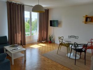 a living room with a table and chairs and a window at Appartement lumineux idéalement situé à proximité de musées équipements sportifs salle de spectacle commerces in Caen
