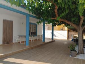 un patio con mesa, sillas y un árbol en Chalet playa, en Benicarló