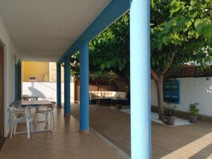 a patio with blue columns and a table and chairs at Chalet playa in Benicarló