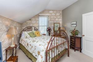 a bedroom with a bed and a stone wall at Jolly's Haus in Fredericksburg
