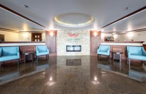 a waiting room with blue chairs and a bar at Red Roof Inn & Suites Wilmington – New Castle in New Castle