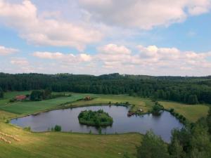 an island in the middle of a lake in a field at Domek letniskowy Rancho do wynajęcia 7osobowy Rybaczówka in Banie Mazurskie +12 photos