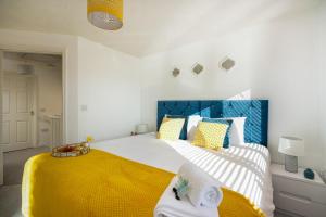 a bedroom with a large bed with a yellow blanket at KVM - Whitebeam House great location by KVM Serviced Accommodation in Peterborough