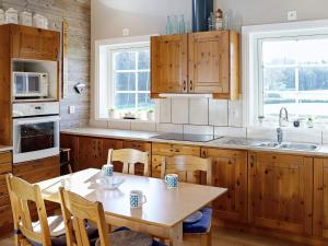 uma cozinha com armários de madeira e uma mesa com cadeiras em 6 person holiday home in VITTSJ em Vittsjö