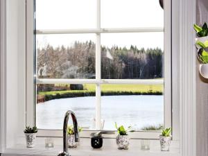 a kitchen window with a view of a lake at 6 person holiday home in VITTSJ in Vittsjö