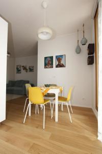 uma sala de jantar com uma mesa e cadeiras amarelas em ALBAmare em Trani