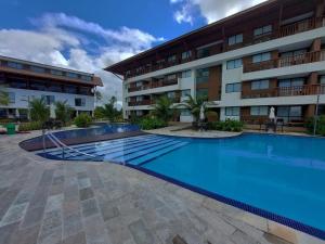 a swimming pool in front of a building at Cupe Beach Living - Porto de Galinhas in Porto De Galinhas