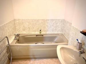 eine große weiße Badewanne im Bad mit Waschbecken in der Unterkunft Spacious King Room with Ensuite in Launton