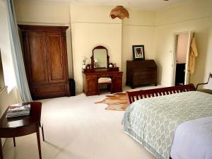 Schlafzimmer mit einem Bett, einer Kommode und einem Spiegel in der Unterkunft Spacious King Room with Ensuite in Launton