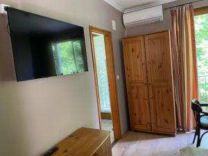 salon z telewizorem z płaskim ekranem na ścianie w obiekcie Gimi Vendégház w mieście Baja