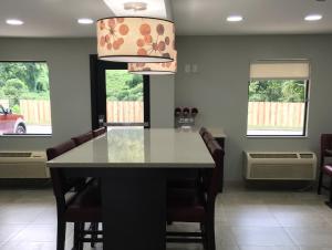 a kitchen with a table with chairs and a chandelier at Red Roof Inn PLUS+ Birmingham East – Irondale/Airport in Birmingham
