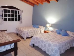 1 dormitorio con 2 camas y ventana en Cabaña de Mima Mazamitla, en Mazamitla