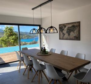 ein Esszimmer mit einem Holztisch und Stühlen in der Unterkunft Villa Pura Corsica with sea view and private pool in Conca