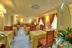 a restaurant with yellow tables and chairs with yellow tables and chairs at Hotel Panorama in Olbia