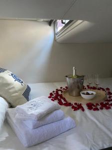 Una cama con toallas, copas de vino y flores. en Douro4sailing, en Oporto
