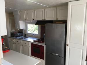 a kitchen with a stainless steel refrigerator and a window at Mobil home Parc Montana in Gassin