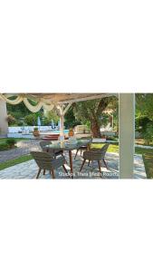 patio ze stołem i krzesłami pod parasolem w obiekcie Studios Thea Fresh Rooms Thassos w mieście Limenas