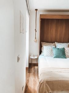 a bedroom with a bed with a wooden headboard and a table at VillaMar Figueira da Foz in Figueira da Foz