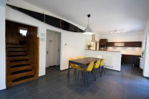 a kitchen and dining room with a table and yellow chairs at Chili House Tiszafüred in Tiszafüred