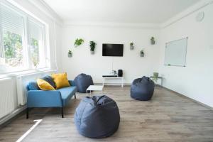 a living room with two blue chairs and a tv at Chili House Tiszafüred in Tiszafüred