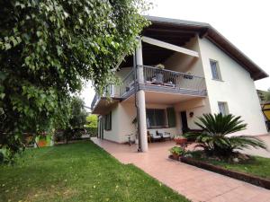 ein Haus mit einem Balkon und einem Hof in der Unterkunft Maison N&M in Desenzano del Garda