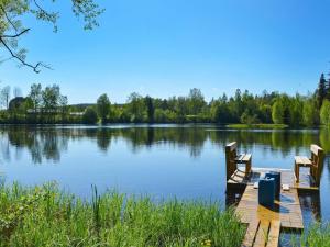 un muelle en un lago con dos sillas. en 7 person holiday home in J RBO, en Åshammar