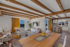 a living room with wooden ceilings and a table and chairs at NEW! Milan's House with pool, Mediterranean in Makarska