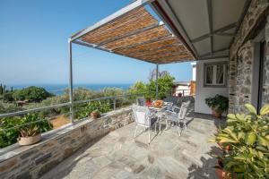 a patio with a table and chairs and the ocean at Oneiro Cottage in Skopelos Town