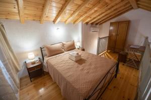 a bedroom with a large bed in a room with wooden floors at Oneiro Cottage in Skopelos Town