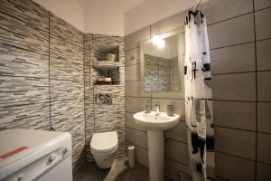 a small bathroom with a sink and a toilet at Oneiro Cottage in Skopelos Town +43 photos