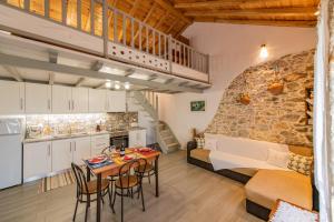 a kitchen and a living room with a table and chairs at Oneiro Cottage in Skopelos Town