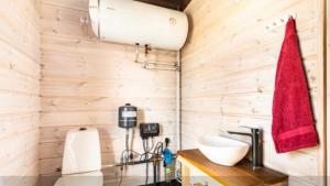 baño con paredes de madera, lavabo y toalla roja en Spithami Seaside Wooden Chalet, en Spithami