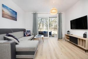 a living room with a couch and a tv at Fabulous Apartments - Euronia in Pobierowo