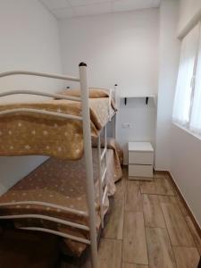 a group of bunk beds in a room with a wooden floor at Apartamentos Sane in Noja