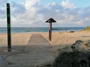 a wooden boardwalk on a beach with the ocean at Apartamentos Sane in Noja