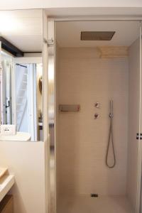 y baño con ducha y puerta de cristal. en Alcova Cellini Bell'Italia, en Cisternino