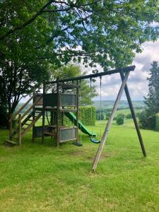 a playground with a swing in a field at Les Caliciades 3 à Gros-Fays in Bièvre