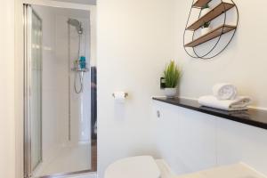 a bathroom with a shower and a toilet and a mirror at 2 Bedroom 2 Bathroom Apartment in Central Milton Keynes with Free Parking - Contractors, Relocation, Business Travellers in Milton Keynes +27 photos