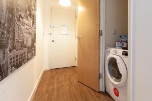 a hallway with a washing machine in a room at 2 Bedroom 2 Bathroom Apartment in Central Milton Keynes with Free Parking - Contractors, Relocation, Business Travellers in Milton Keynes