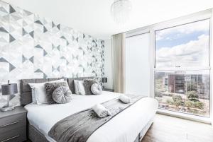 a bedroom with a large bed and a large window at 2 Bedroom 2 Bathroom Apartment in Central Milton Keynes with Free Parking - Contractors, Relocation, Business Travellers in Milton Keynes