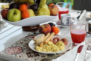 un tavolo con un piatto di cibo e un cesto di frutta di Maison N&M a Desenzano del Garda