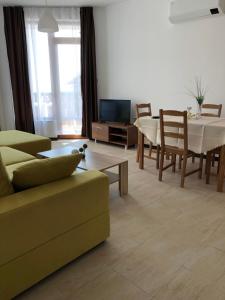 a living room with a couch and a dining room table at Aquamarine Apartments in Sveti Vlas